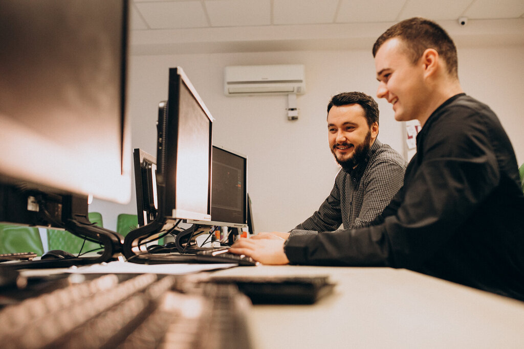 young male webdesigners working in front of computer screens